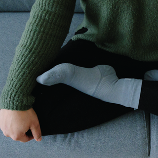 Woman wearing grey Apolla support socks with ankle support