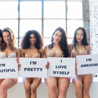 Women holding signs of Positivity and Self-love 
