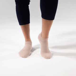 Woman wearing Apolla Performance no-show compression socks for low-profile support and improved circulation.